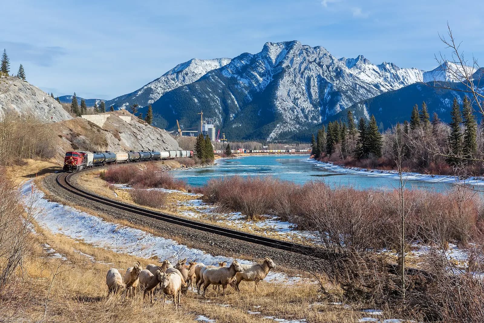 A Canadian Pacific Railway freight train hauled by General Electric AC4400CW nr. 9739 follows the Bow River near Exshaw, Alberta, Canada.